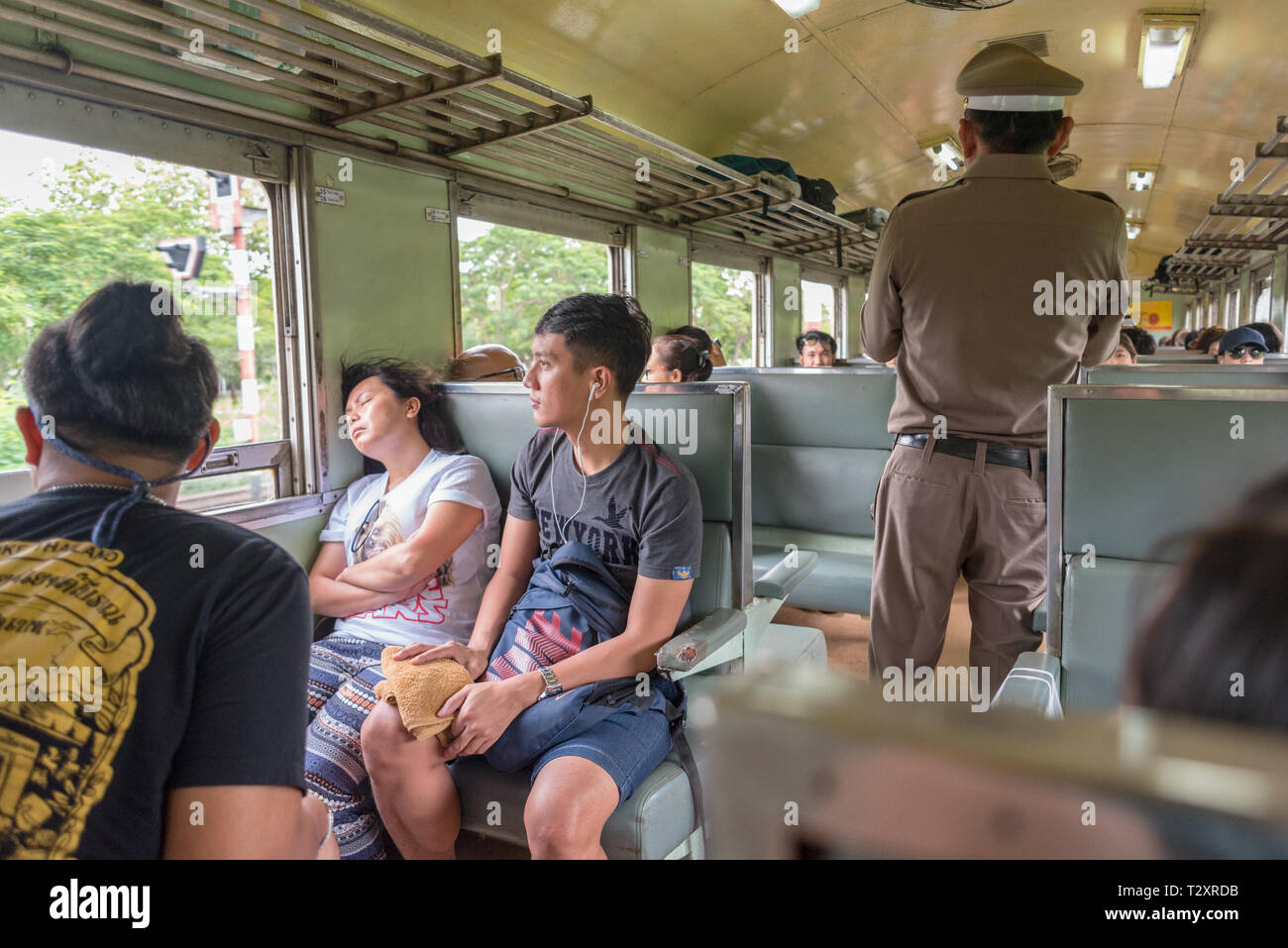 Bangkok, Tailandia - 18 agosto 2018: passeggeri e un conduttore in una classe terza vettura di un treno Bangkok - Nam Tok. Foto Stock