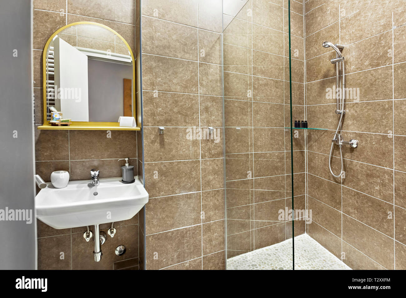Moderno bagno interno con lavandino e specchio, vetro cabina doccia con  mattonelle di marmo circondano Foto stock - Alamy