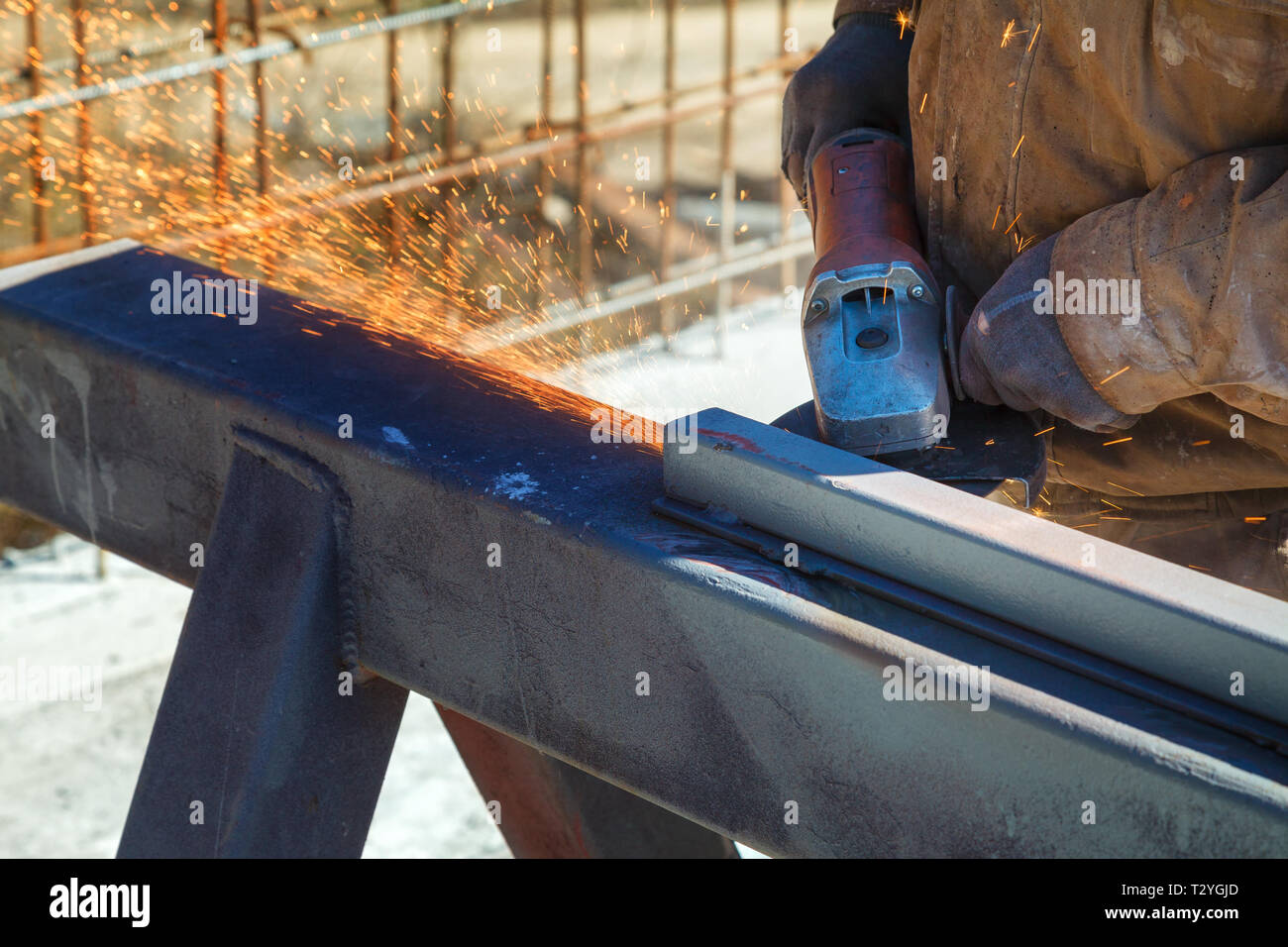 Lavoratore taglia una struttura di metallo con un cavo elettrico Foto Stock