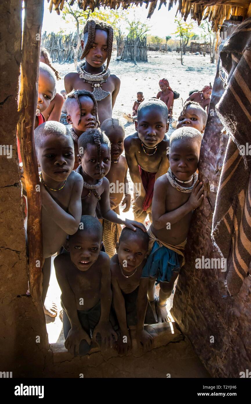 Molti curiosi i bambini in cerca di un rifugio Himba, Kaokoland, Namibia Foto Stock