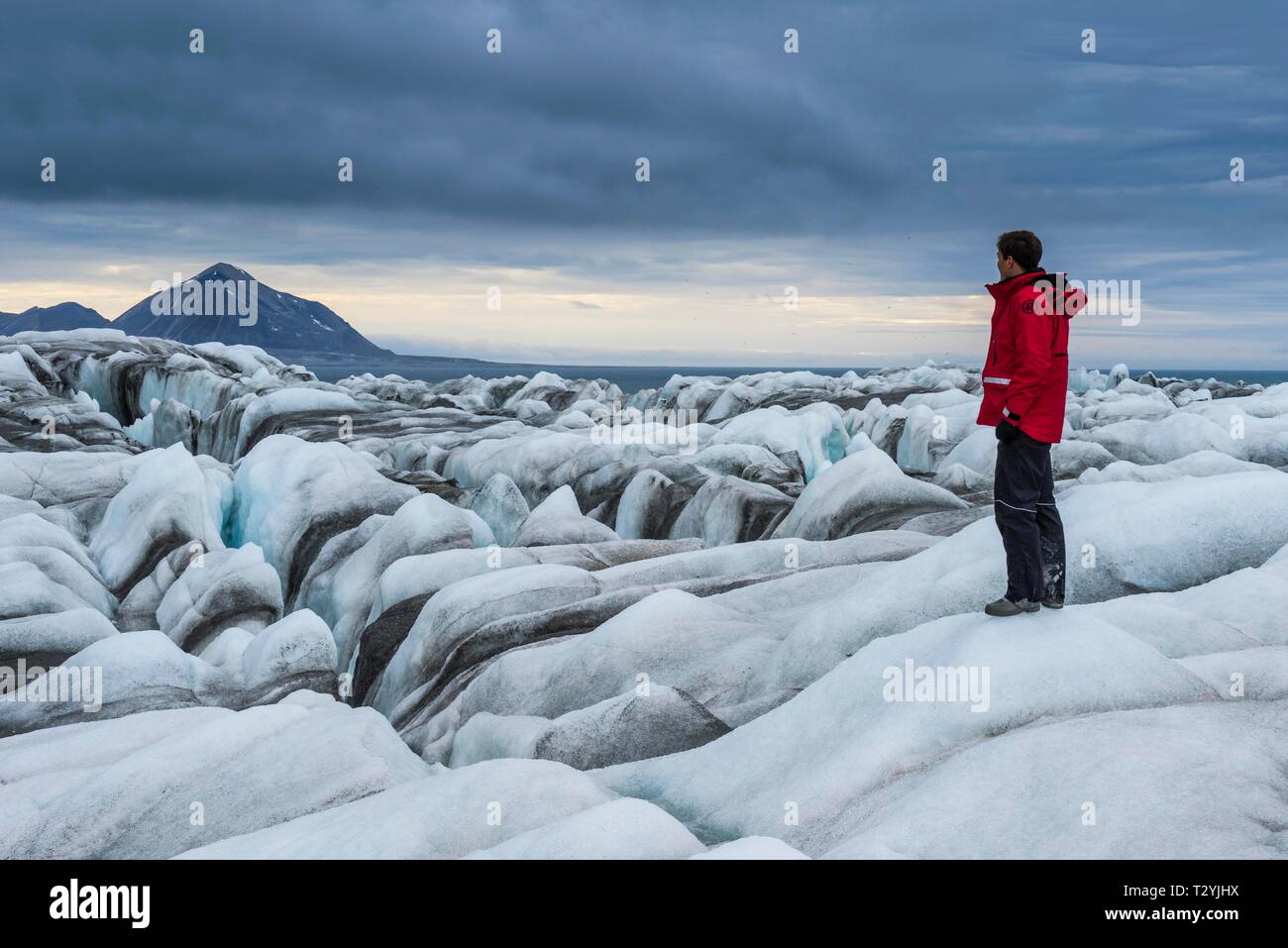 Turista, l'uomo in piedi sul ghiacciaio del grande ghiacciaio in Hornsund, artiche Svalbard, Norvegia Foto Stock