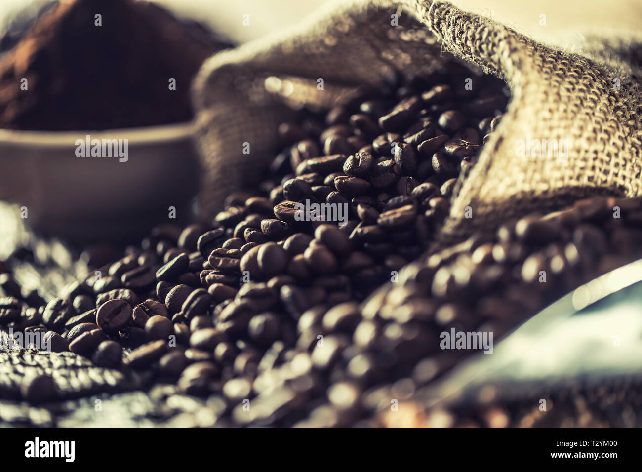 I chicchi di caffè nel sacco di tela sul vecchio tavolo in legno. Foto Stock