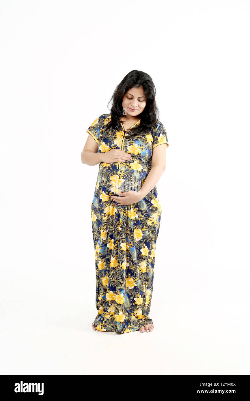 Donna incinta toccando la pancia. Isolato su uno sfondo bianco. Foto Stock