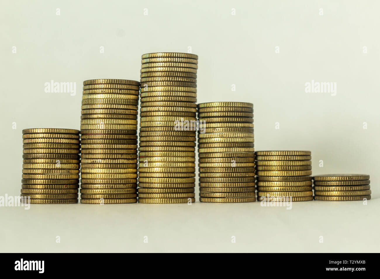 Pile di monete di rame su uno sfondo bianco. Il movimento lungo l'onda sinusoidale. Una buona immagine per un sito di finanza, denaro, collezione di relazioni. Foto Stock