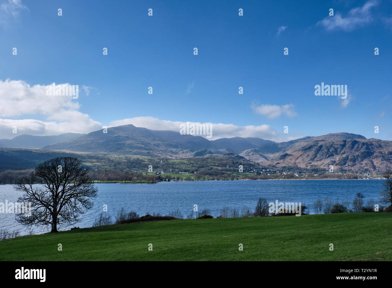 Il vecchio uomo di Coniston, Wetherlam e Coniston village visto da Brantwood sulle rive di Coniston Water, Lake District, Cumbria Foto Stock