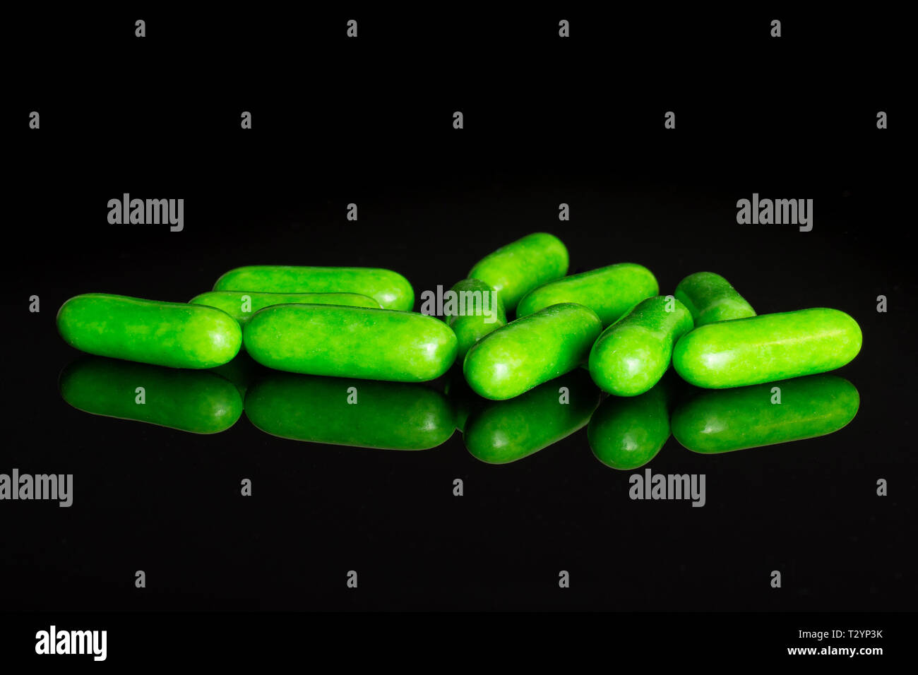 Sacco di tutto il dolce verde liquirizia comfit isolato sul vetro nero Foto Stock