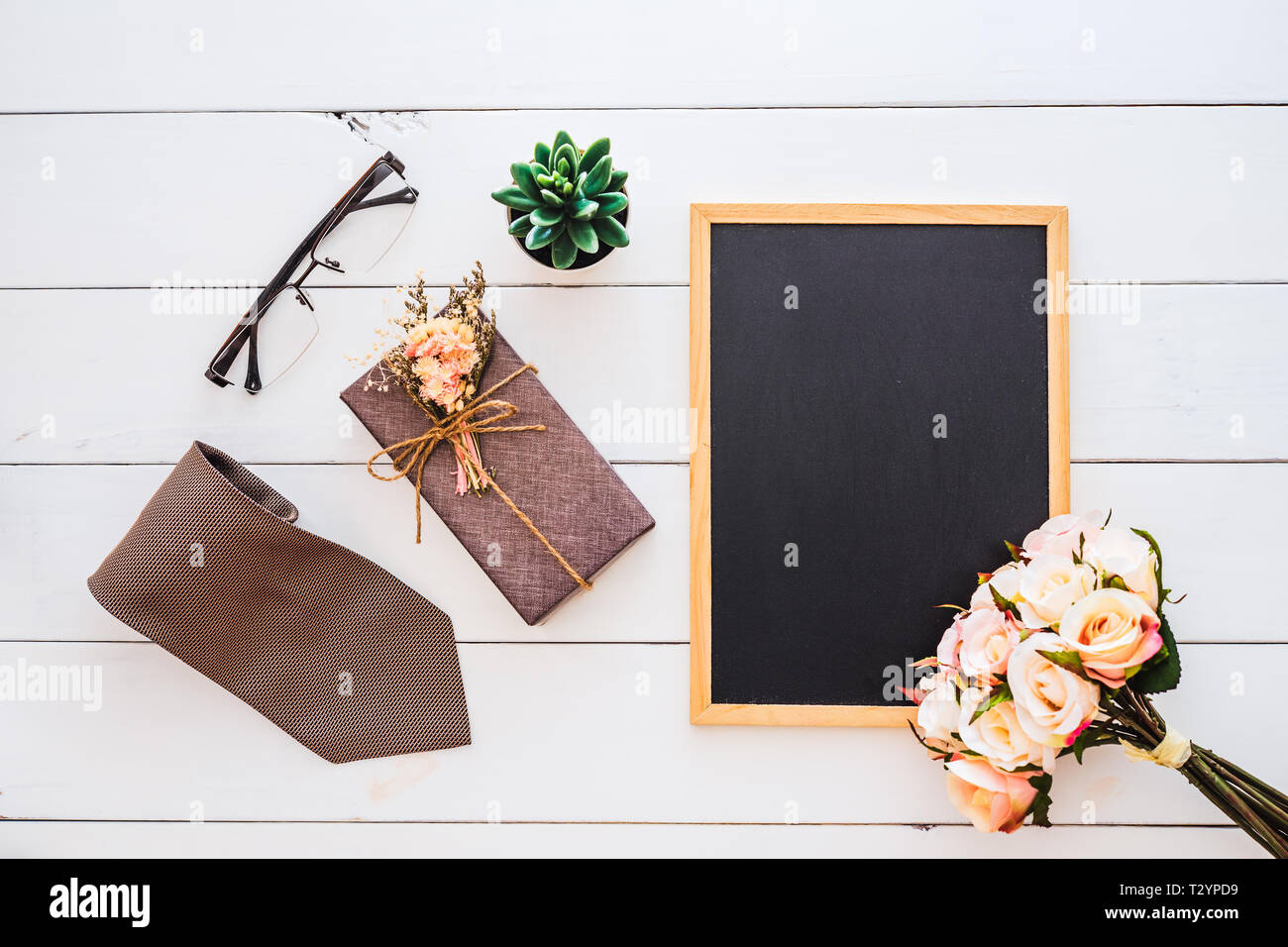 Piano immagine di laici di scatola regalo, cravatta, bicchieri, fiori di rose e uno spazio vuoto lavagna. Vista da sopra con copia spazio per la vostra pubblicità di testo. Felice Fathe Foto Stock