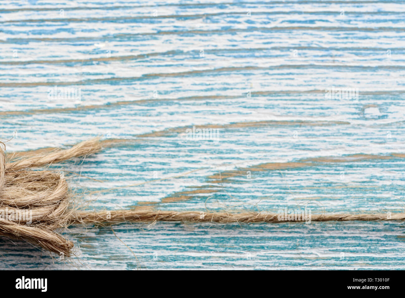 La iuta spago su blu sullo sfondo di legno Foto Stock