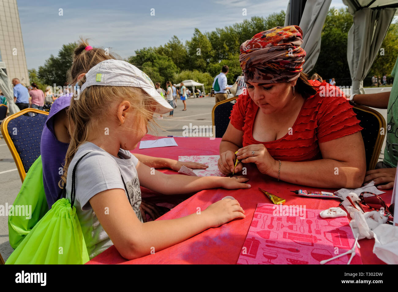 Tyumen, Russia - Agosto 26, 2016: Open Day di Sberbank per bambini. Artista applicando henna tattoo sulla mano ragazza Foto Stock