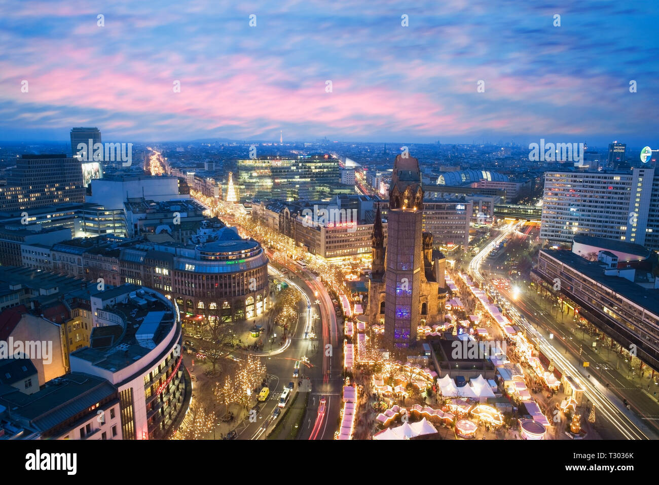 Vista in elevazione del Kaiser Wilhelm Memorial Church e i Mercatini di Natale al tramonto, Foto Stock