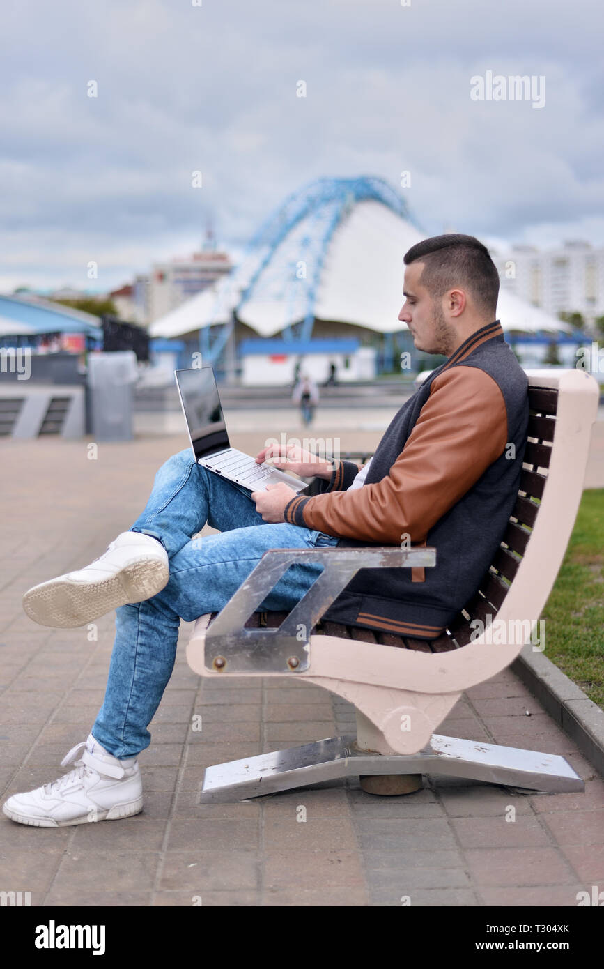 Giovane ragazzo in giacca di pelle e i jeans. freelancer lavora al