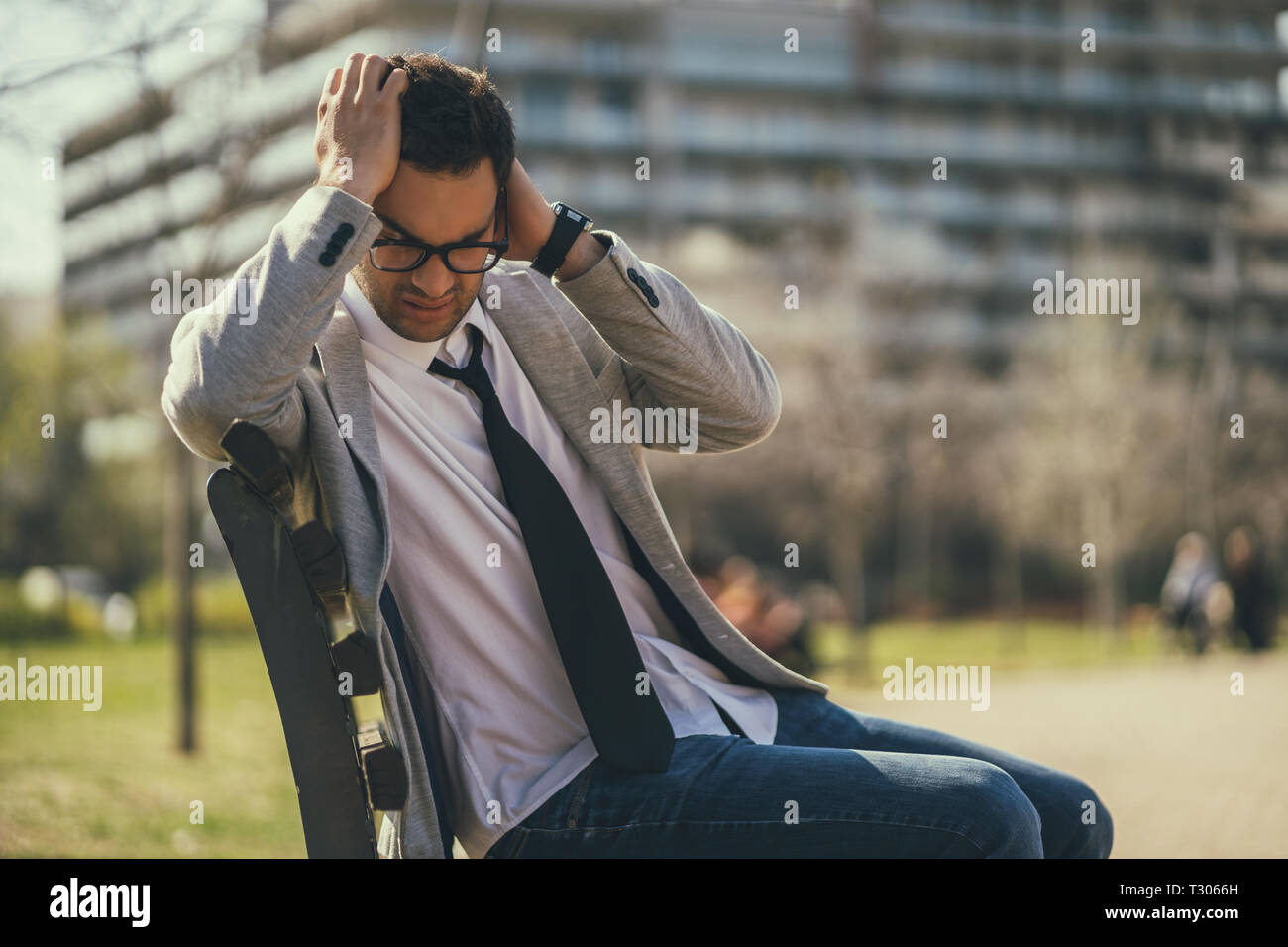 Giovane imprenditore è seduto in posizione di parcheggio dopo essere licenziato. Egli è premuto. Foto Stock