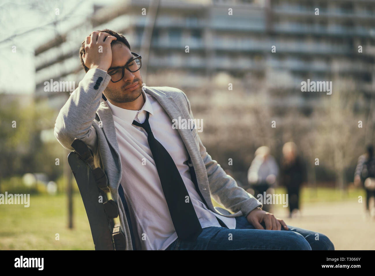 Giovane imprenditore stanco è a riposo nella posizione di parcheggio dopo il lavoro. Foto Stock