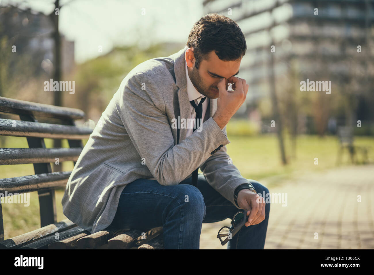 Giovane imprenditore è seduto in posizione di parcheggio dopo essere licenziato. Egli è premuto. Foto Stock