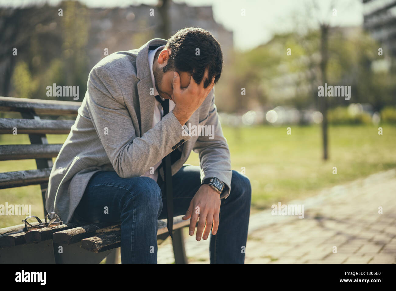 Giovane imprenditore è seduto in posizione di parcheggio dopo essere licenziato. Egli è premuto. Foto Stock
