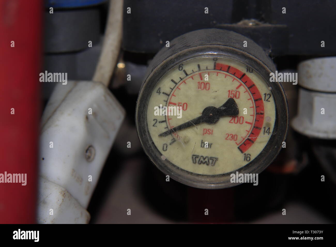 Il misuratore di pressione su un compressore di aria in un confuso garage. Foto Stock