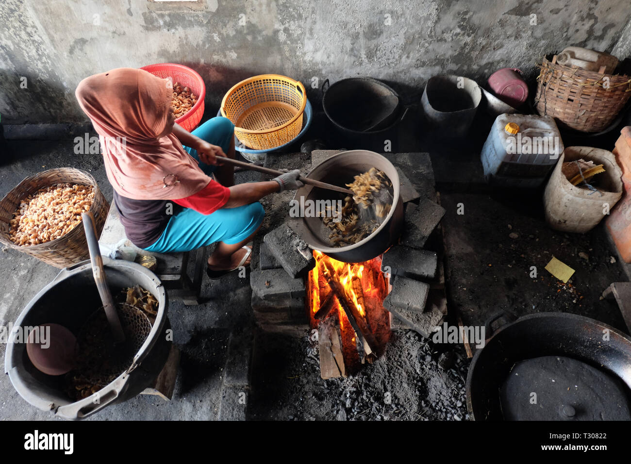 Surabaya indonesia, 15 gennaio 2018. Una donna è per cucinare melanzana cracker utilizzando una stufa tradizionale Foto Stock