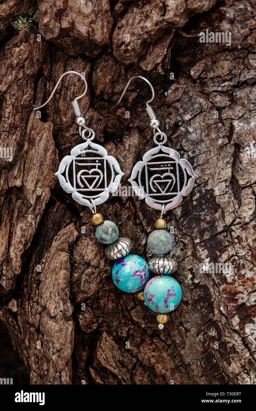 Metallo spirituale e pietra orecchini di perle naturali sullo sfondo di  legno Foto stock - Alamy