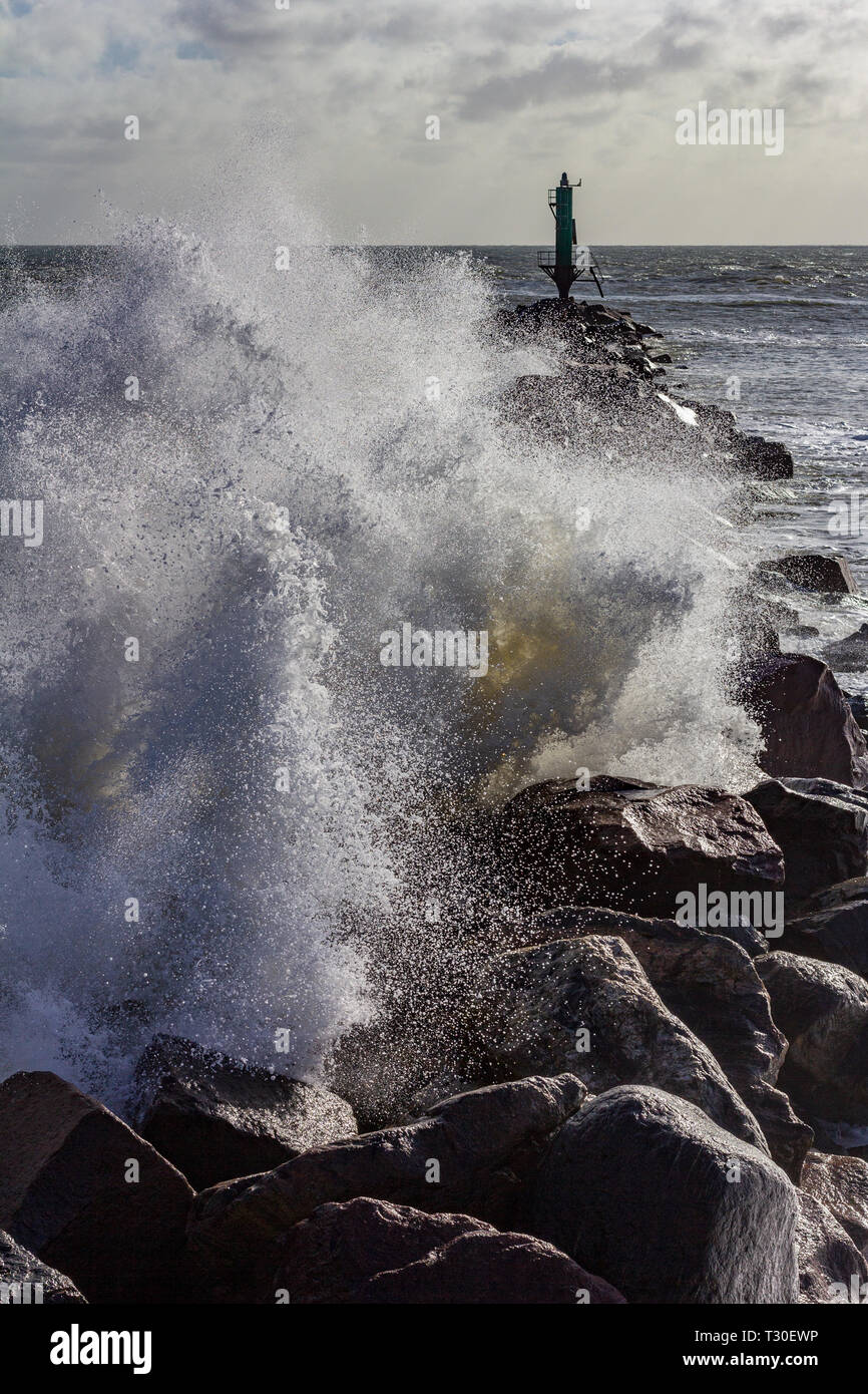 Ondata di schiantarsi su una roccia jetty all'entrata del porto di Ramsgate nel Kent, England, Regno Unito Foto Stock