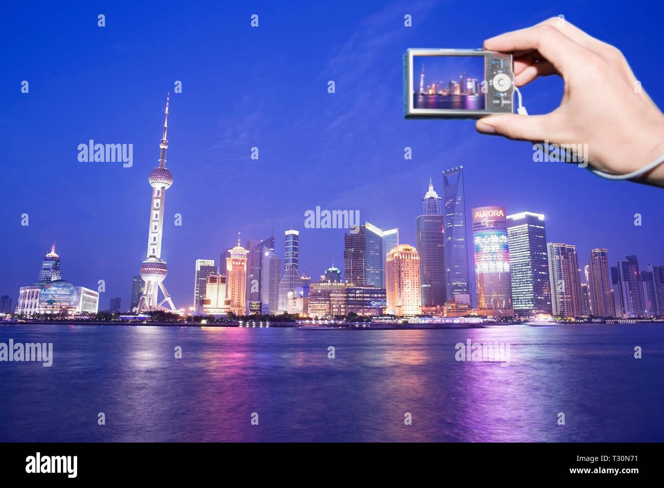 Punto di vista personale di un turista a fotografare il Pudong skyline al tramonto. Shanghai in Cina. Foto Stock
