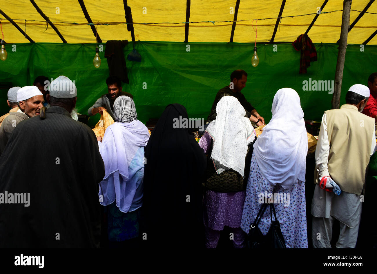 4 aprile 2019 - Srinagar Kashmir, 4 aprile 2019. La gente acquistare spuntini da un temporaneo stallo vicino al santuario Hazratbal alla vigilia del FUSC-e-Mehraj noto anche come Al Isra' a Srinagar, che celebra la notte quando il Profeta Maometto ascese al cielo. Migliaia di devoti raccogliere e celebrare il 27 Rajab, il settimo mese del calendario islamico, che porta un grande significato nell Islam come secondo la Sura Isra Profeta Muhammad è stato preso per una sola notte viaggio verso il cielo che è descritto come un fisico e spirituale (credito Immagine: © Muzamil Mattoo/IMAGESLIVE tramite Z Foto Stock