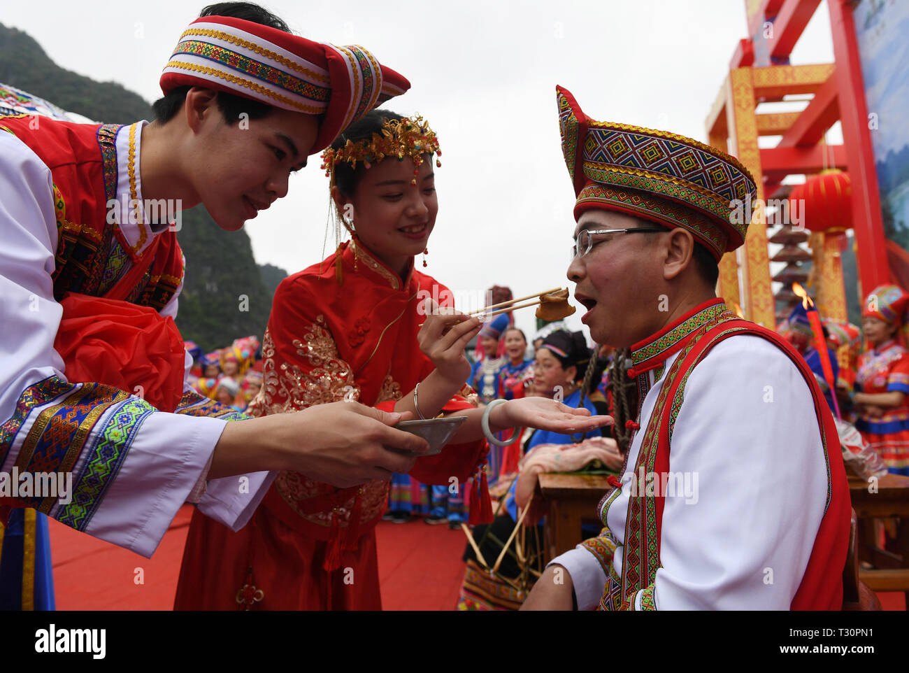 Du an, della Cina di Guangxi Zhuang Regione autonoma. 4 apr, 2019. Una "coppia" trattare i loro 'padre' con carne durante una performance di nozze personalizzati delle Zhuang gruppo etnico in Du an Yao contea autonoma, a sud della Cina di Guangxi Zhuang Regione autonoma, 4 aprile 2019. Credito: Lu Boan/Xinhua/Alamy Live News Foto Stock
