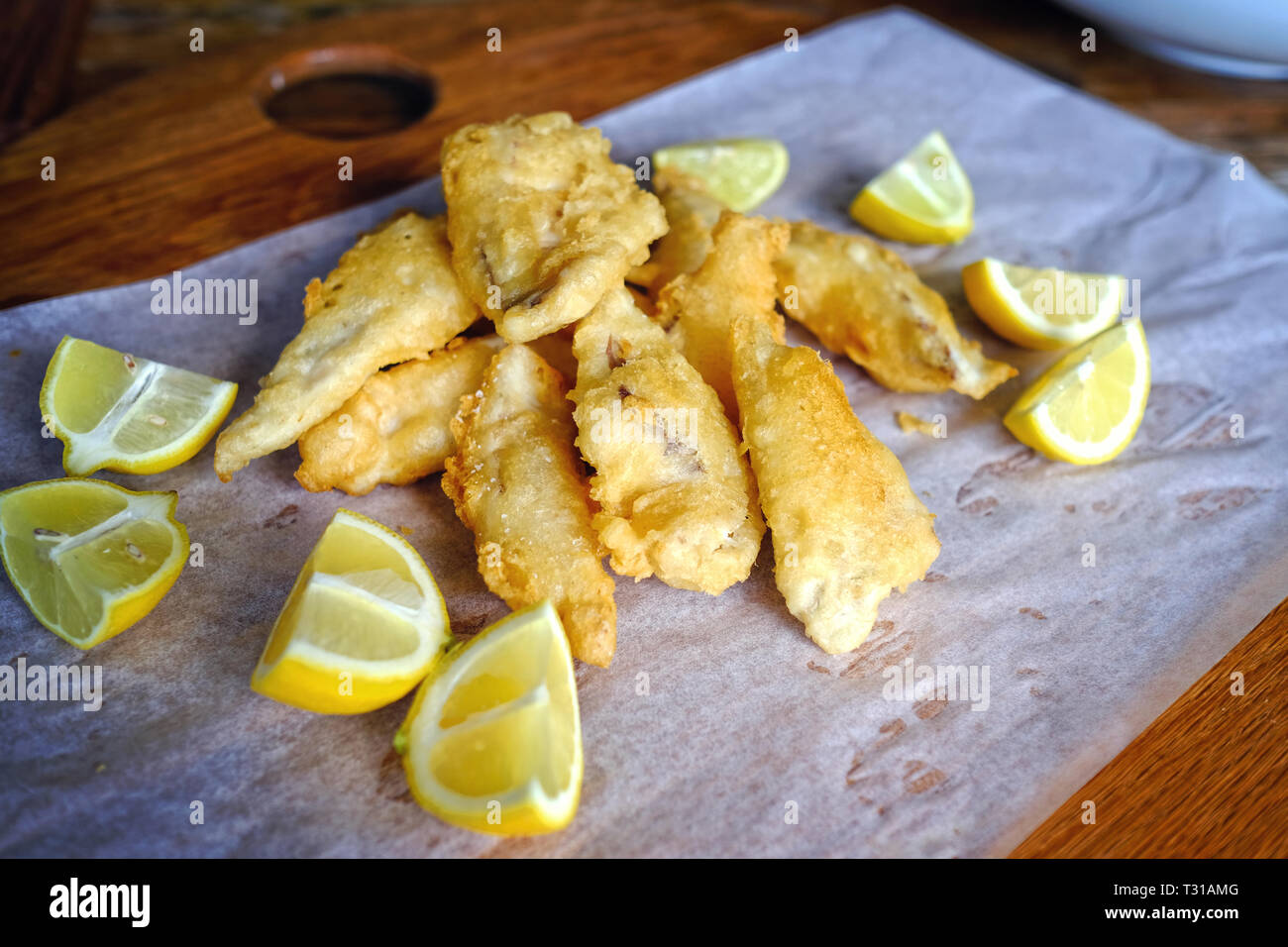 Close up di birra pastella con pesce piatto di limone Foto Stock