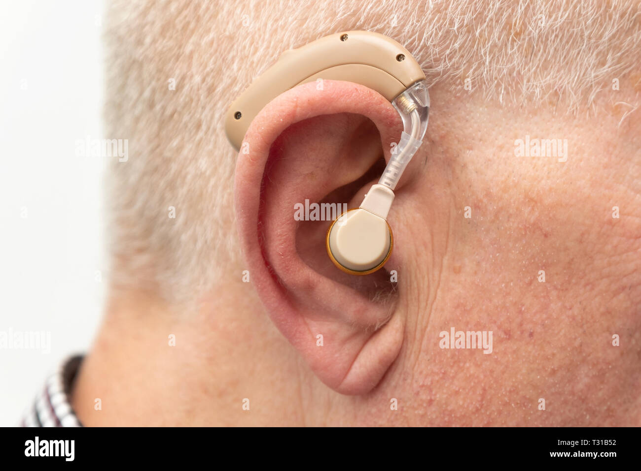 Hearing Aid nell'orecchio di età compresa tra uomo vecchio. Senior utilizzando i moderni apparecchi acustici Foto Stock