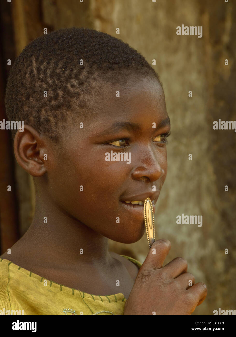 Ritratto di un bambino del Malawi tenendo un cucchiaio maniglia per la sua bocca Foto Stock