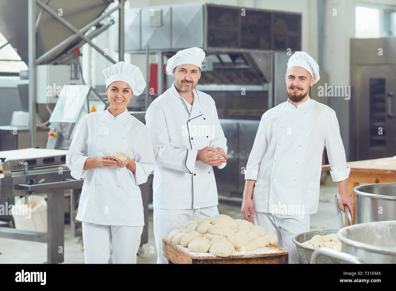 Un gruppo di fornai sorrisi al forno Foto Stock