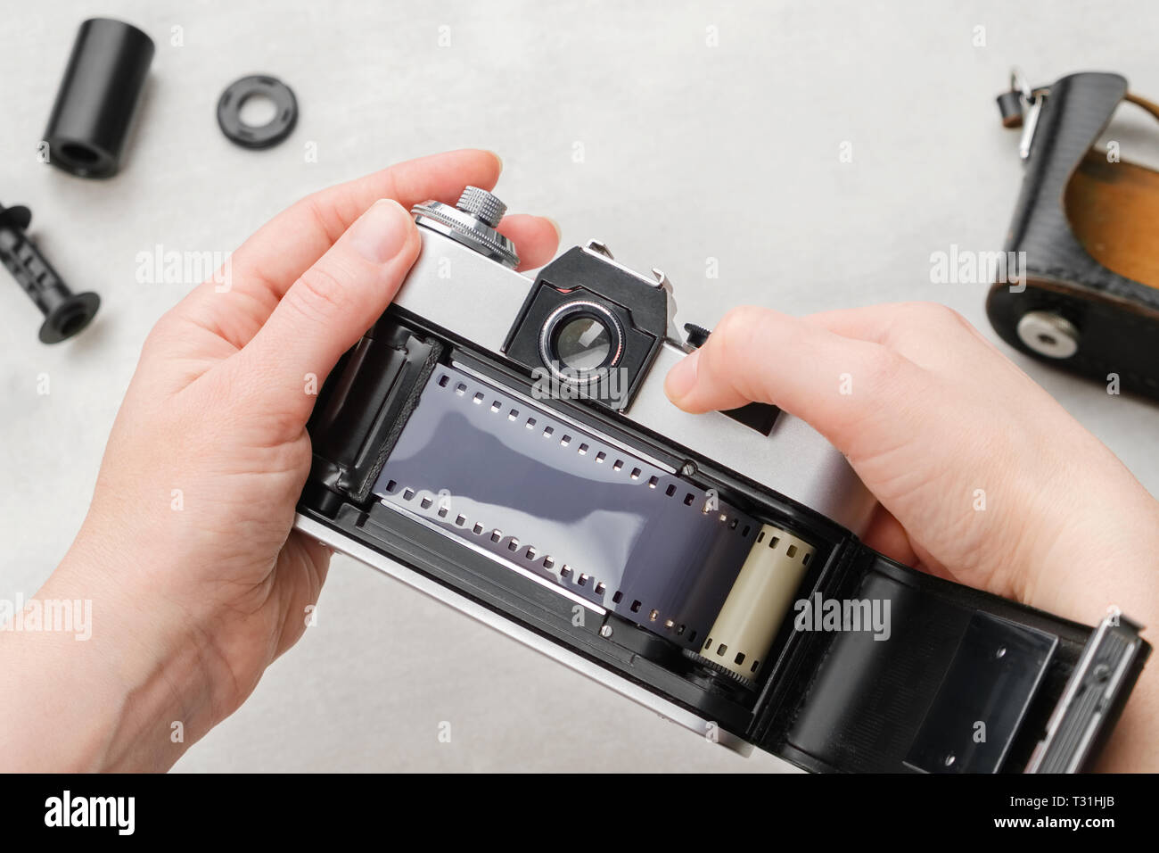 Mani il caricamento di film nel retro della fotocamera reflex. Foto Stock