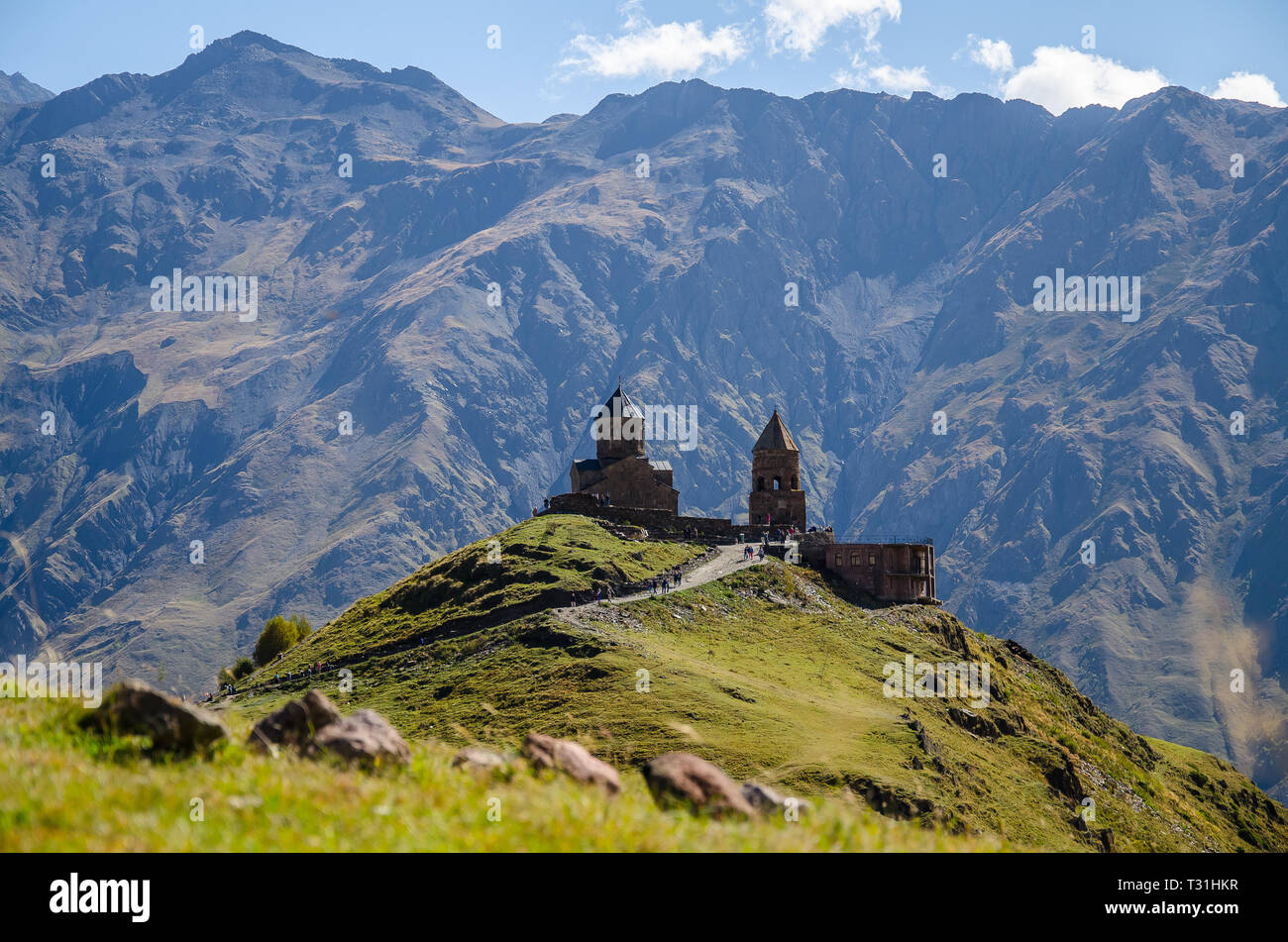 Chiesa della Santa Trinità in Kazbegi mountain range vicino a Stepantsminda vista montagne del Caucaso in background. Foto Stock