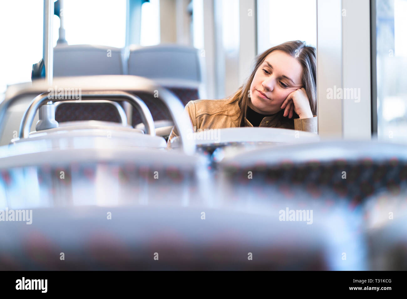 Triste donna stanca in treno o in autobus. Passeggero annoiato o infelice seduto in tram appoggiato a mano. Ha turbato la signora su un autobus ritardato. Foto Stock
