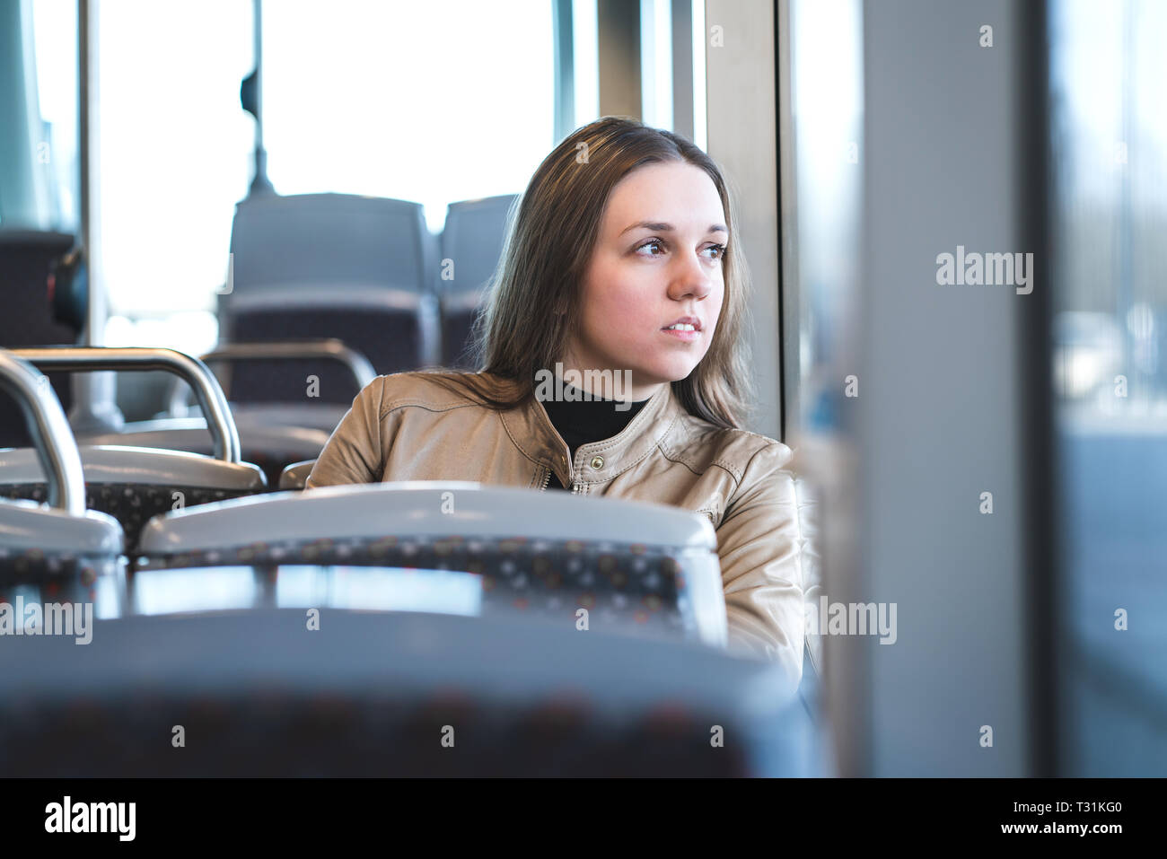 Grave donna in treno o bus cerchi attraverso la finestra. Considerato passeggero in mezzi di trasporto pubblici. Sconvolto lady in viaggio. Foto Stock