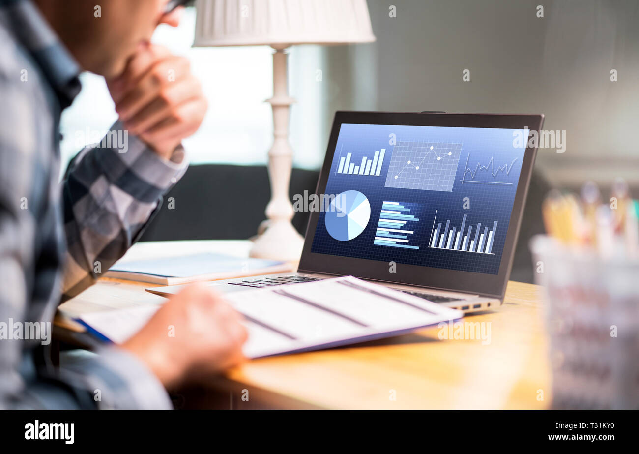 Uomo che legge la relazione di affari. Notebook con grafici finanziari, statistiche e progressi del mercato. Imprenditore che conta il bilancio o l'imposta sul reddito. Foto Stock