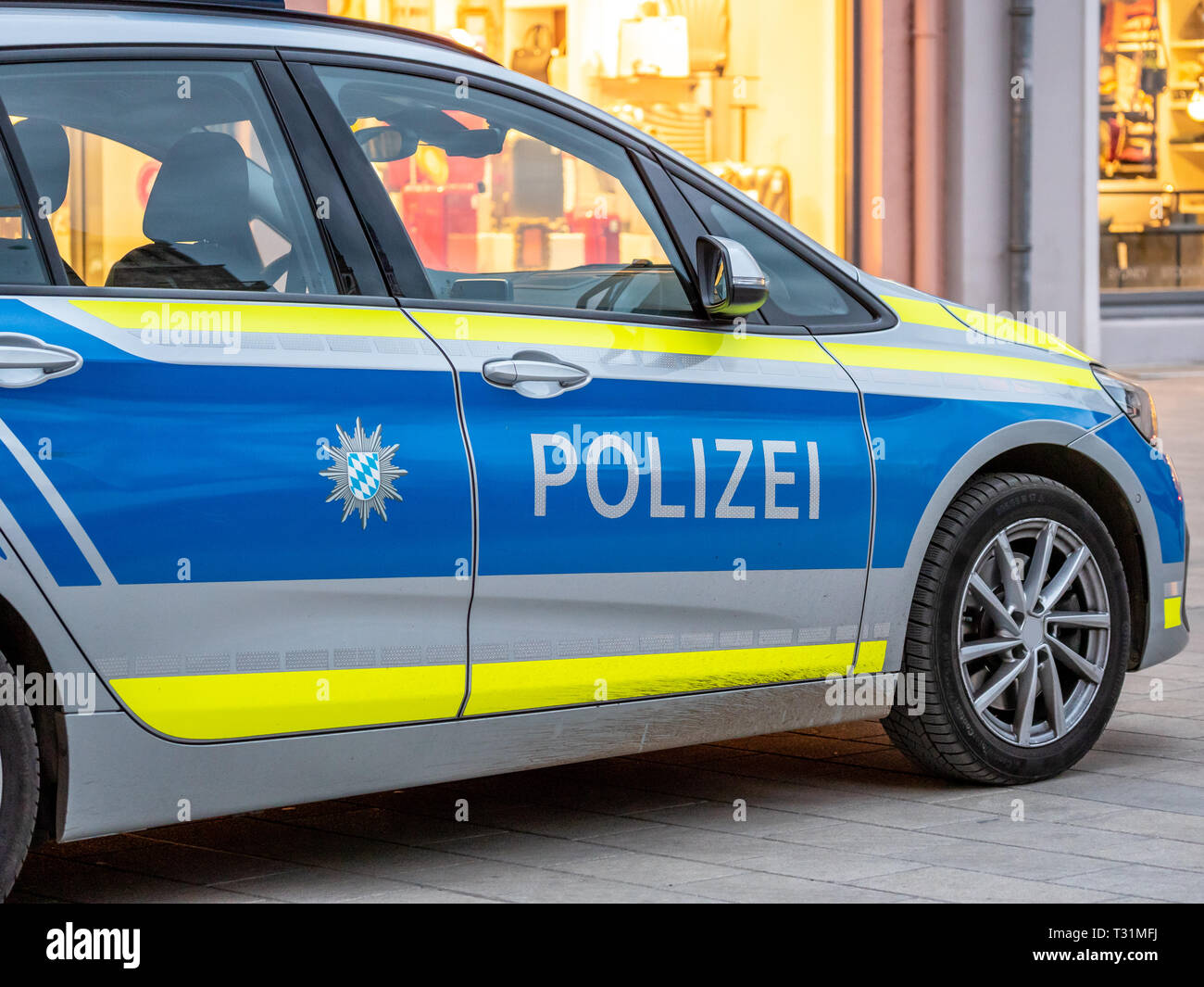 Imaga di una macchina della polizia tedesca in blu e strisce gialle dal Land della Baviera con le lettere polizei sullo sportello Foto Stock