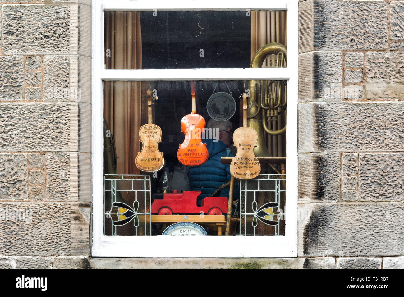 Falkland, Regno Unito - 23 Marzo 2019: strumenti musicali antichi nella finestra di seconda mano e negozio di antiquariato nel villaggio di Falkland in Scozia Foto Stock