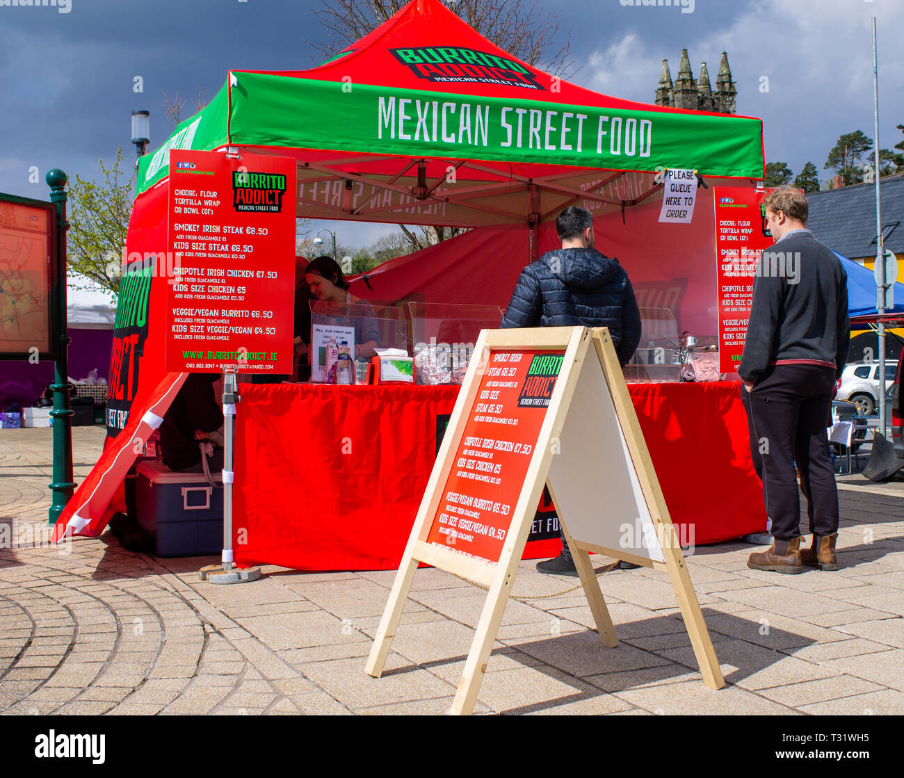 La gente in una coda per il cibo messicano a un open air di stallo alimentare. West Cork, Irlanda Foto Stock La gente in una coda per il cibo messicano a un open air di stallo alimentare. West Cork, Irlanda Foto Stock