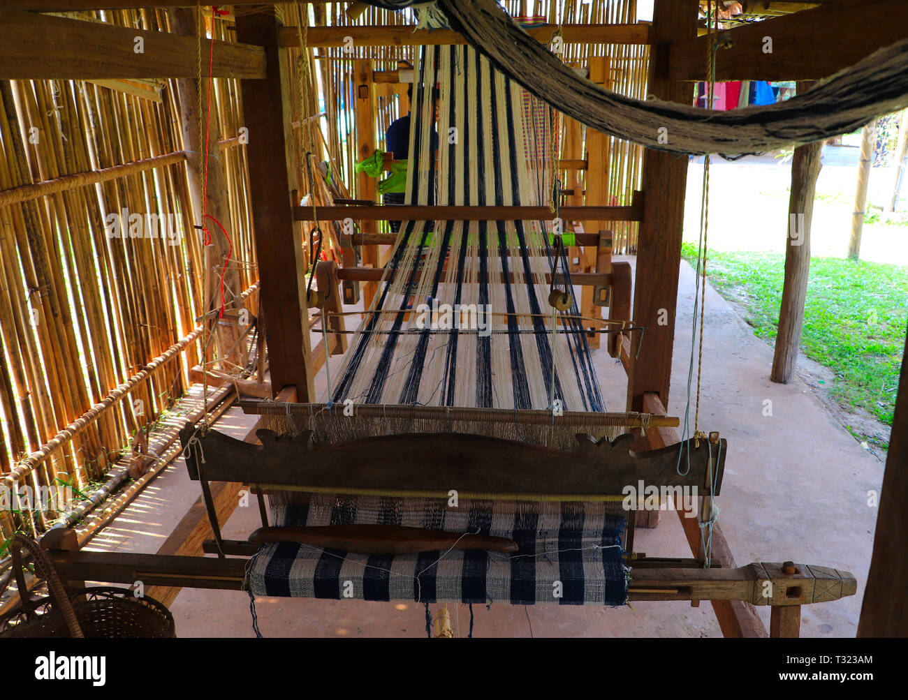 In legno telaio di tessitura con pattern colorati e tessili tessitura navetta - Artigianato tradizionale nozione Foto Stock