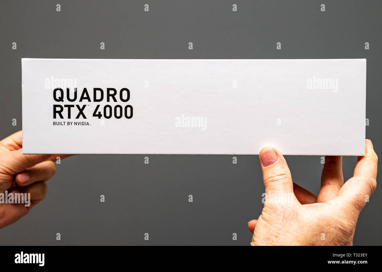 Parigi Francia - Mar 28 2019: Senior uomo che mostra le scatole di cartone prima di unboxing di Nvidia Quadro di RTX 4000 GPU per workstation dotate di nuovi multiprocessori streaming anime del tensore di vista superiore Foto Stock