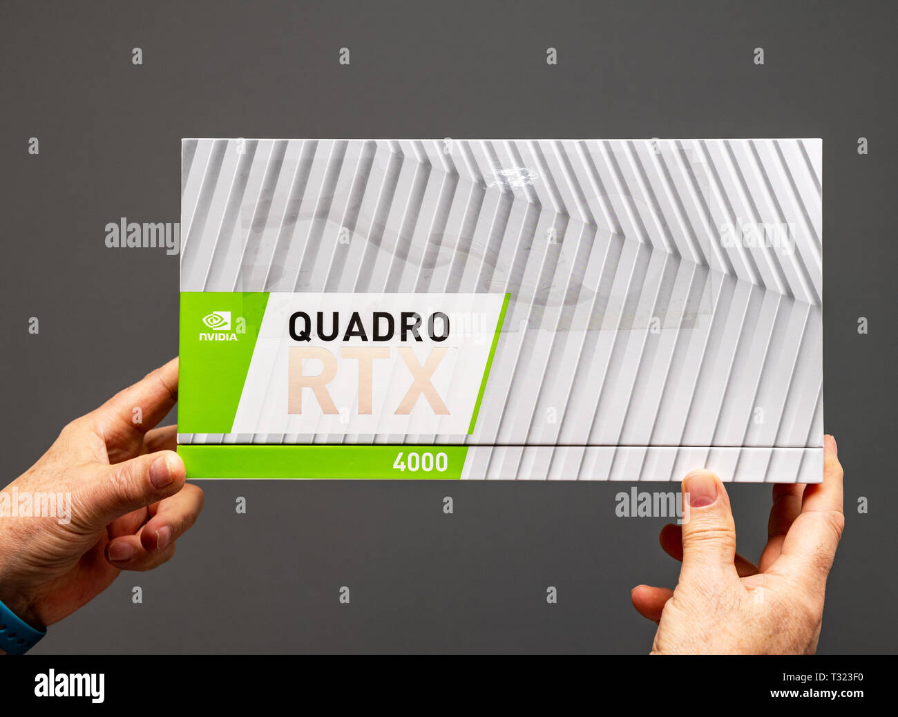 Parigi Francia - Mar 28 2019: Senior uomo che mostra le scatole di cartone prima di unboxing di Nvidia Quadro di RTX 4000 GPU per workstation dotate di nuovi multiprocessori streaming anime del tensore di Vista frontale Foto Stock