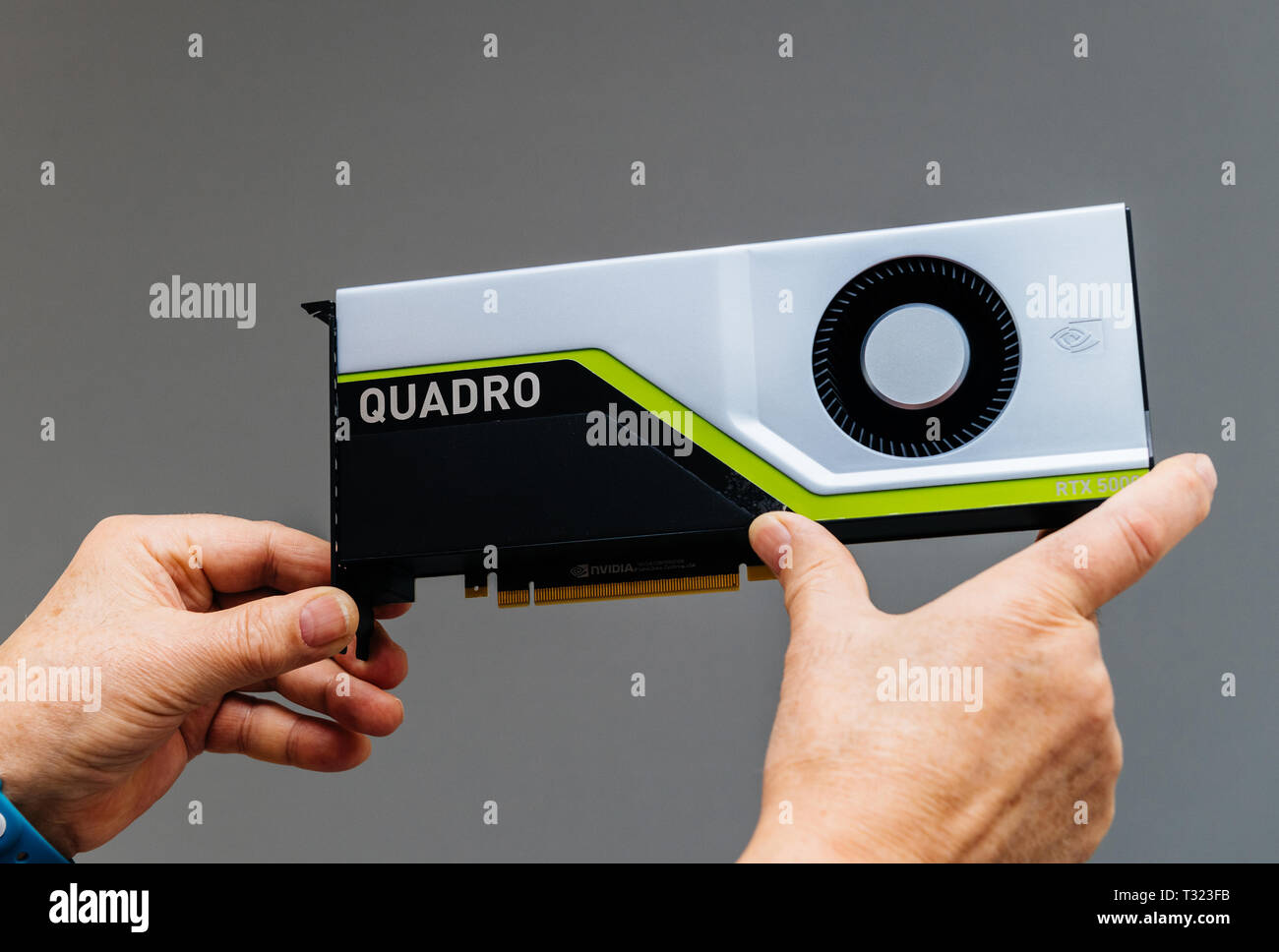 Parigi, Francia - Mar 28 2019: Senior uomo mostra ultima Nvidia Quadro RTX workstation 5000 GPU con texture mapping di unità, rendere le unità di uscita, streaming multiprocessori, anime del tensore di sfondo grigio Foto Stock