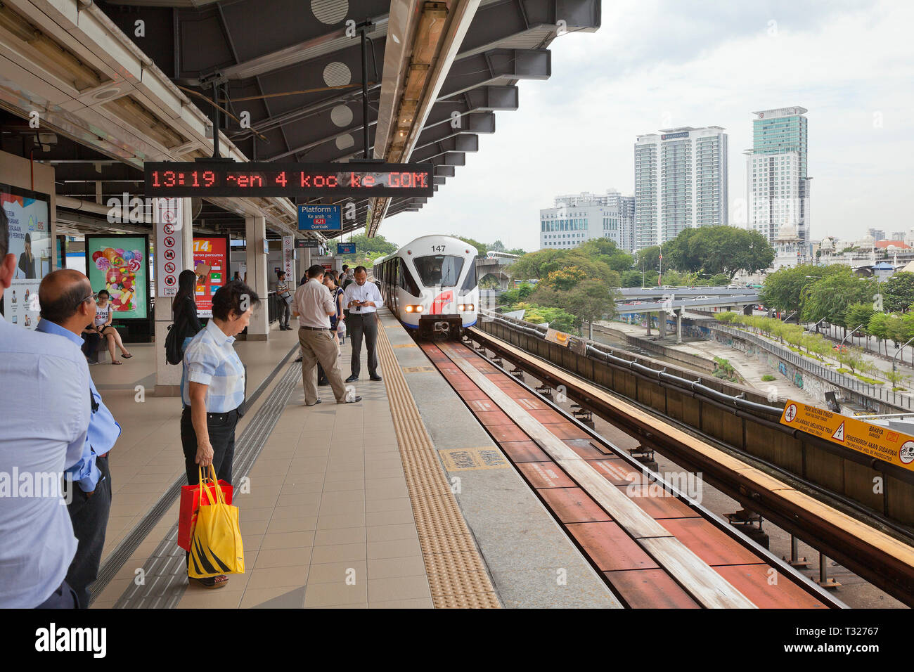 Kuala Lumpur, Malesia, Rapid KL Light Railway, trasporto in treno arrivando alla stazione di " commuters " piattaforma, pendolari in attesa di bordo. Foto Stock