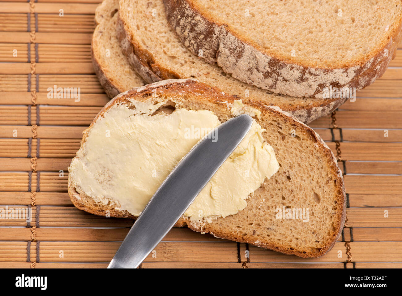 Un coltello diffusione di burro sul pane Foto Stock