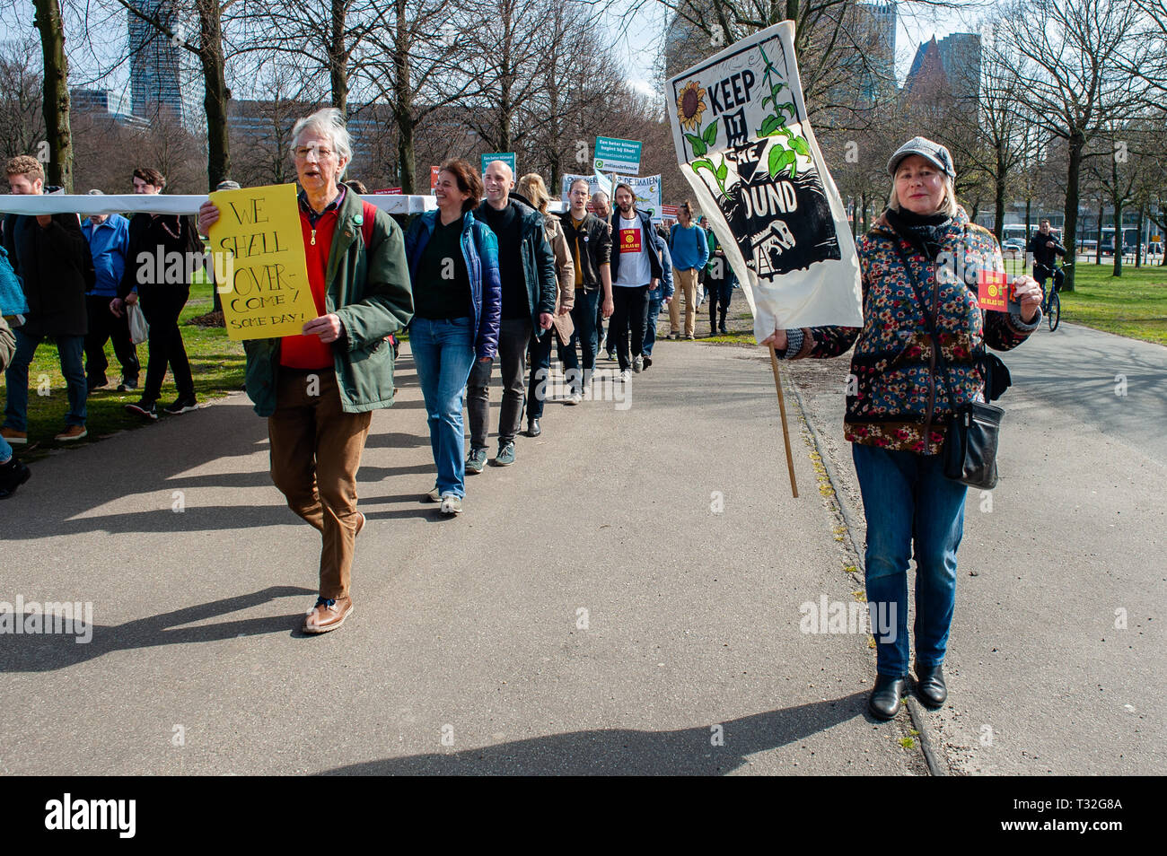 I dimostranti sono visti tenendo cartelloni durante l'anti-guscio dimostrazione. Centinaia di persone si sono radunate a Malieveld. Da lì siamo andati a piedi fino alla sede dell'industria del petrolio e del gas company Shell per effettuare una consegna personalmente di più di 13.000 firme dai cittadini olandesi backing la querela. Questo sarebbe un nuovo approccio giuridico nella lotta al cambiamento climatico, il primo processo a sfidare direttamente il modello di business e alla strategia di crescita di una compagnia petrolifera. Sette ambientali e le organizzazioni per i diritti umani nei Paesi Bassi sono state preparate a citare in giudizio la Royal Dutch Shell se il gigante dell'olio r Foto Stock
