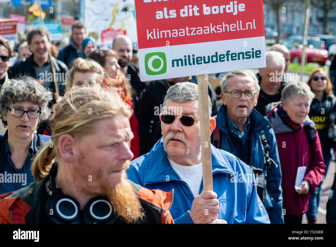 Un manifestante visto tenendo un cartello durante l'anti-guscio dimostrazione. Centinaia di persone si sono radunate a Malieveld. Da lì siamo andati a piedi fino alla sede dell'industria del petrolio e del gas company Shell per effettuare una consegna personalmente di più di 13.000 firme dai cittadini olandesi backing la querela. Questo sarebbe un nuovo approccio giuridico nella lotta al cambiamento climatico, il primo processo a sfidare direttamente il modello di business e alla strategia di crescita di una compagnia petrolifera. Sette ambientali e le organizzazioni per i diritti umani nei Paesi Bassi sono state preparate a citare in giudizio la Royal Dutch Shell se il gigante dell'olio re Foto Stock