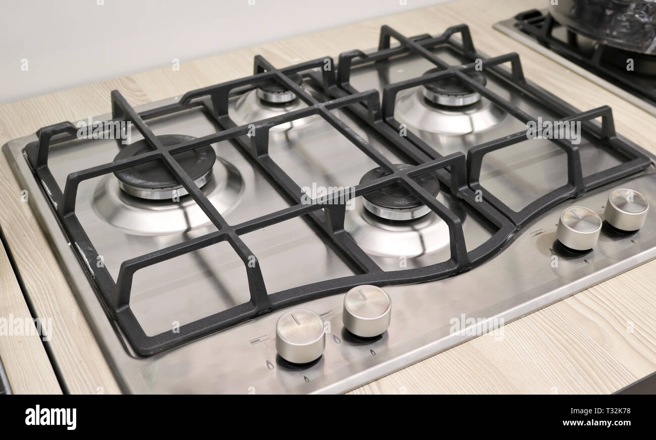 Nuova moderna stufa a gas con quattro fuochi per la cucina, superficie di acciaio inossidabile, ghisa griglie Foto Stock