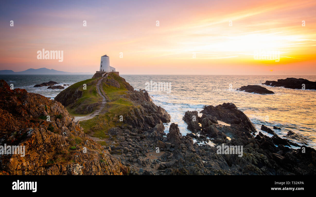 Tramonto spettacolare, faro di Twr Mawr Llanddwyn Island, Anglesey che si affaccia verso l'ingresso meridionale dello stretto di Menai. Fotografia classica del paesaggio britannico. Foto Stock