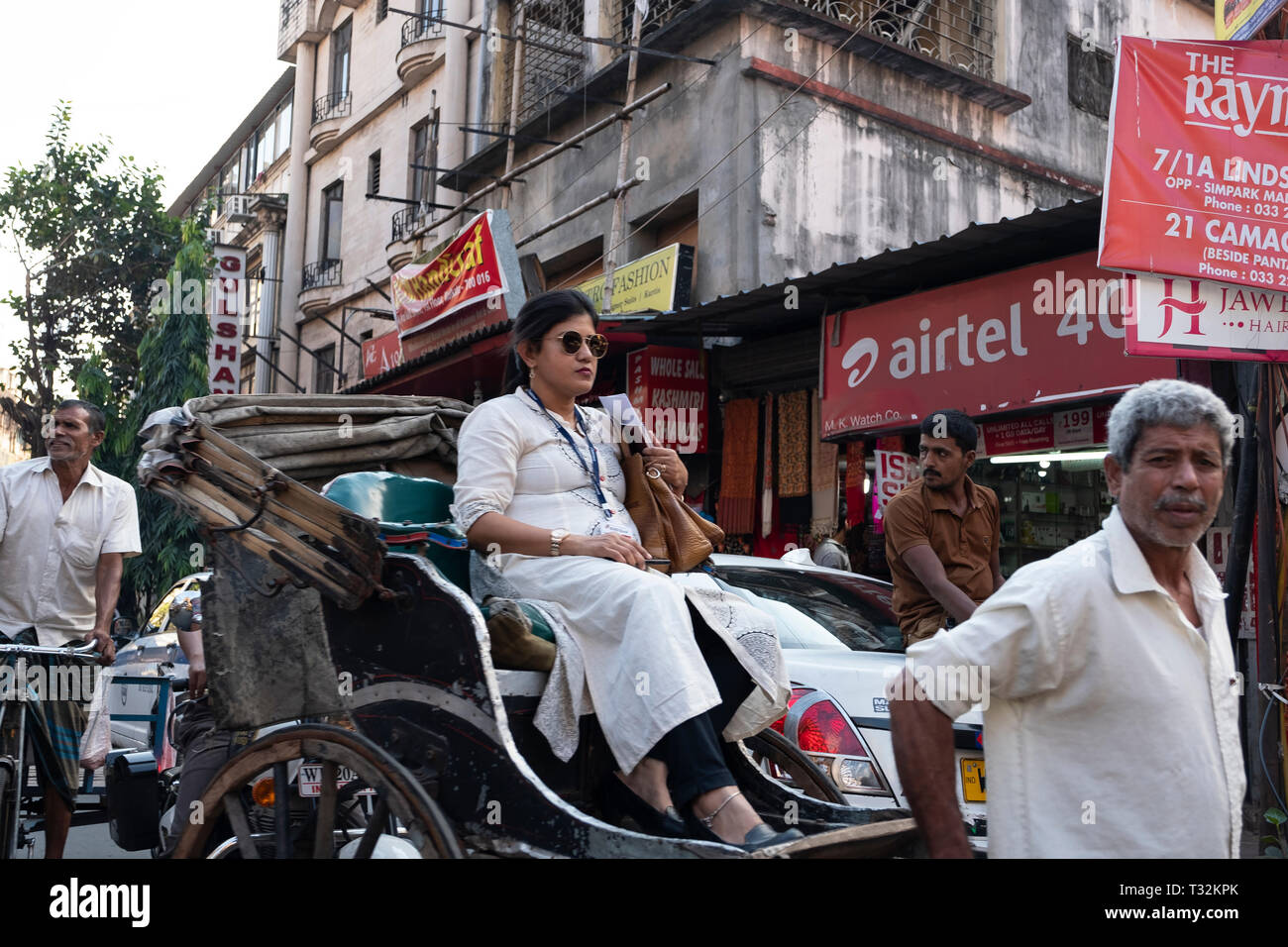 Giovane donna indiana essendo azionati in led man rickshaw in Kolkata, India Foto Stock