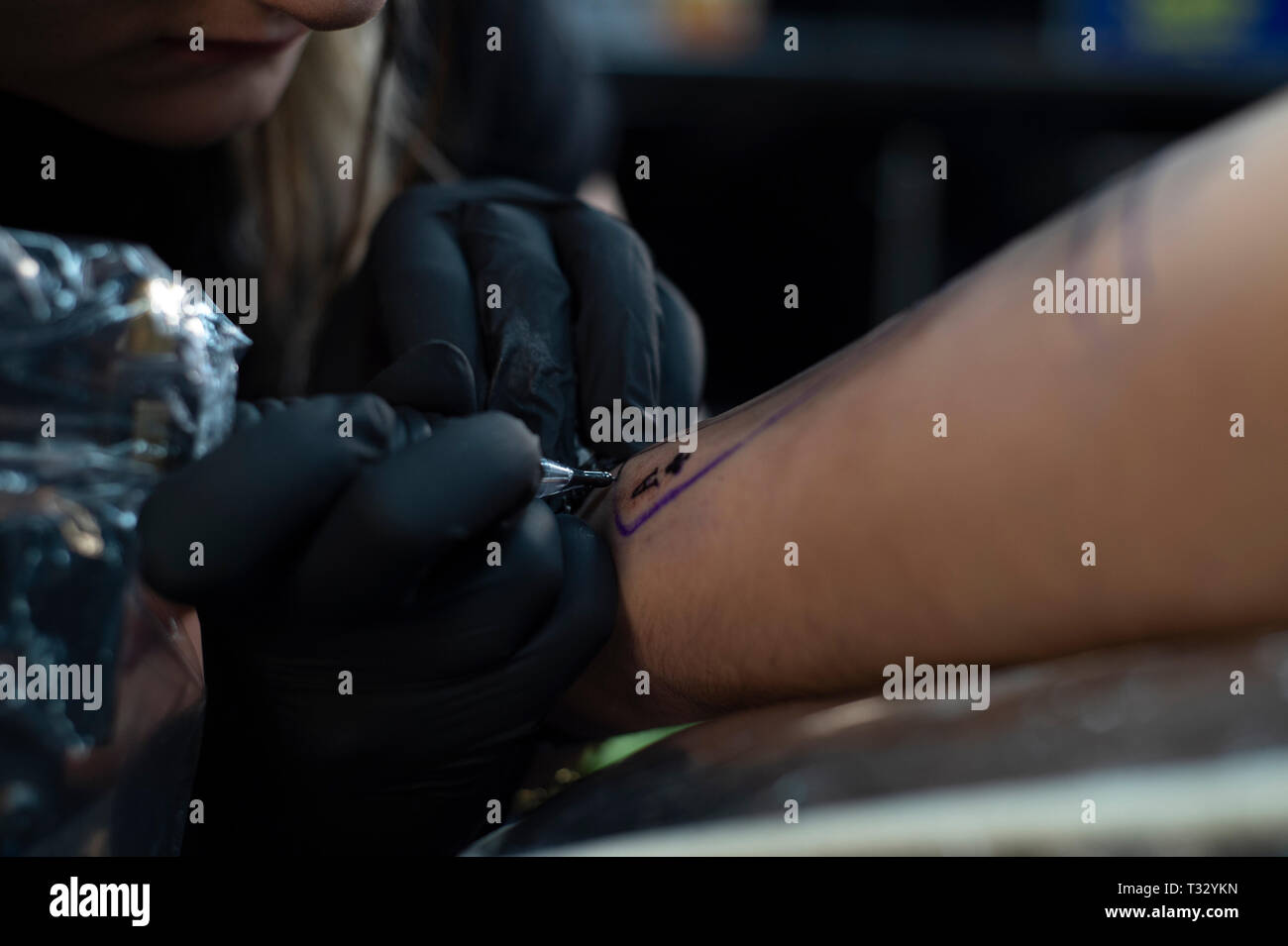 Femmina artista tattoo dando un tatuaggio. Come ottenere un tatuaggio Foto Stock